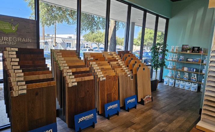 Inside Hicks Flooring in San Antonio Showroom, with hardwood floor samples lined up with floor care supplies on wall shelf. 